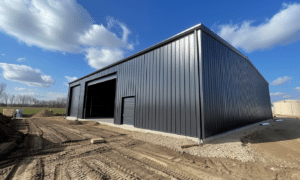 Dark grey steel buildings in a small Alberta town with cloudy skies and rural landscape.